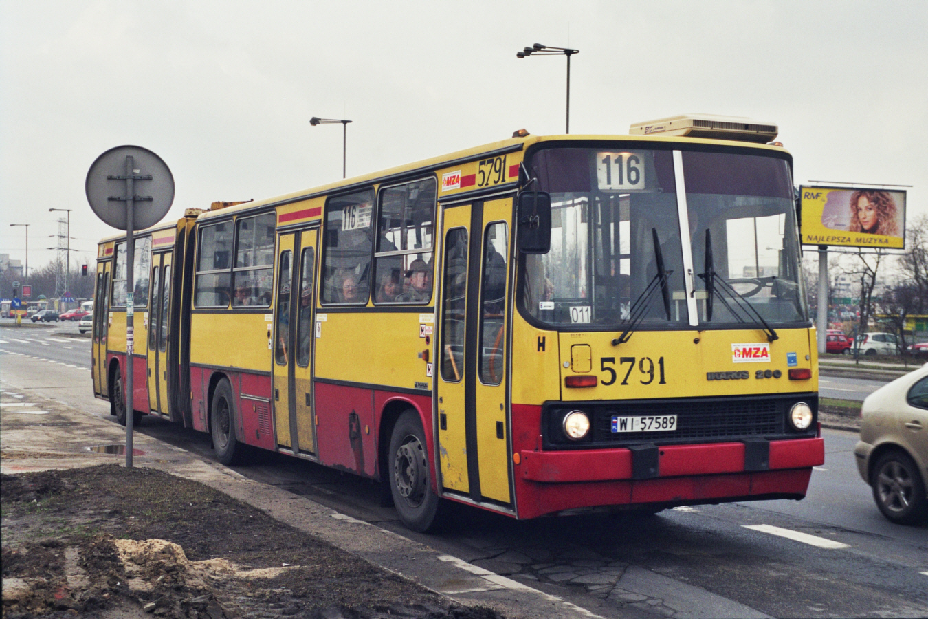 5791
Drugi z serii przedstawiciel rocznika '97 z zajezdni R-9 Chełmska.
Rok 1996 był ubogi w dostawach nowych autobusów. Ikarusów nie było w ogóle, ale zakład R-9 otrzymał jeden egzemplarz przegubowego Jelcza. Ostatnia dostawa Ikarusów z 1997 zaowocowała przydzielenie do zakładu R-9 rekordowej liczby 11 wozów z zakresem numeracji 5759, 5790-5799.
Wozom 5790-5794 numery taborowe wymalowano z szablonu, natomiast koleje egzemplarze miały już numery taborowe w formie naklejek.
Zajezdnia Chełmska dostała sporo Ikarusów, dlatego że nie otrzymywała Neoplanów, jakie już w tym roku dostarczane były seryjnie do niektórych zajezdni.
Wóz 5791 otrzymał w zmianie B kierowca, który wcześniej miał na stałe Ikarusa 2988.
Linia 116 obsługiwana przez R-9 Chełmska na 3 dni przed likwidacją zajezdni.

Foto: P.B. Jezierski
