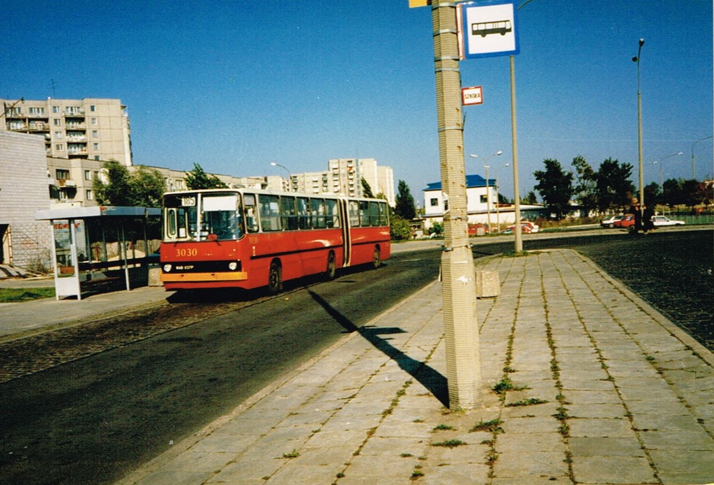 3030
"Trzydziestki" to pierwsza z serii trzech pierwszych '87-ek w Piasecznie. Tu już po CWS. 3030 3033 i 3032 pojawiły się we wrześniu 1987. Numery boczne miały namalowane cienkim szablonem (szczególnie "3" i "0", gdyż te cyfry były najczęściej używane i szablony się szybciej zużywały); przesunięte do przodu, czyli pod oknem za II drzwiami i z lewej symetrycznie na przeciwko, czyli pod V oknem. Jednak mistrzem pierwszego planu jest mimo woli przystanek linii szkolnych.
Słowa kluczowe: Ikarus280 Natolin 3030 185