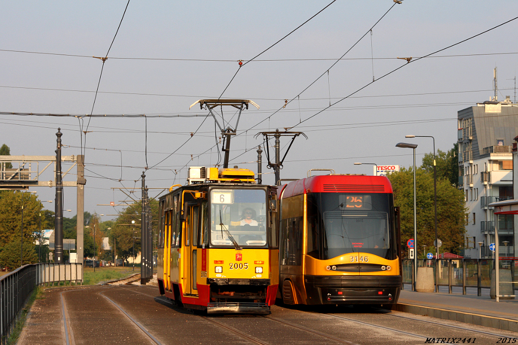 2005
Konstal 105Na, prod. 1987

Kiedy na Bemowie albo Bielanach są jakieś objazdy tramwajowe, zawsze zostaje w to zamieszana szóstka. Tym razem wylądowała aż na Górczewskiej. Przejazd pólkursu trwał prawie 90 minut, czyli mniej więcej tyle ile za czasów, gdy na stałe jeździła z Gocławka na Koło. Ciekaw jestem kto z widocznej na zdjęciu dwójki szybciej dotarł na Grochowską - czy 6 jadące przez Bemowo, Bielany, Młociny, Żoliborz, Muranów i Pragę, czy 26, które po dojechaniu na pętlę Os. Górczewska i odbyciu tam postoju, ruszyło dość prostą drogą w stronę Kamionka i "Wiatraka".
Słowa kluczowe: 105Na 2005 6 Górczewska