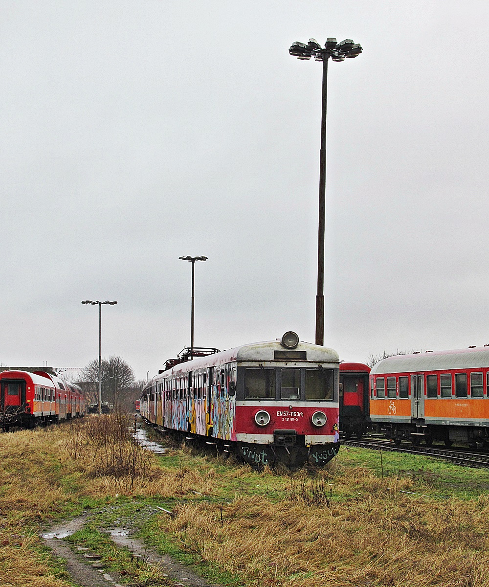 EN57-1163
Wyprodukowany w 1977 roku bordowy kibelek czeka na palnik na stacji Chojnice. 
