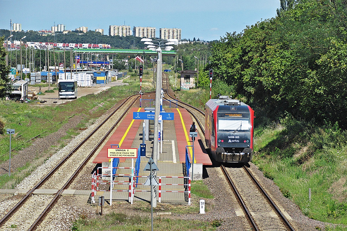 SA106-005
Mała Pesa jako pociąg osobowy relacji Toruń Główny - Grudziądz czeka na godzinę odjazdu na stacji Grudziądz Mniszek. Przez okres wakacji tak naprawdę jest to stacja początkowa dla tego pociągu, z Kornatowa przywiozła pasażerów Setra S315 UL CWA 5H66 z firmy Trans-Tur Orzechowo jako Kolejowa Komunikacja Autobusowa.   
